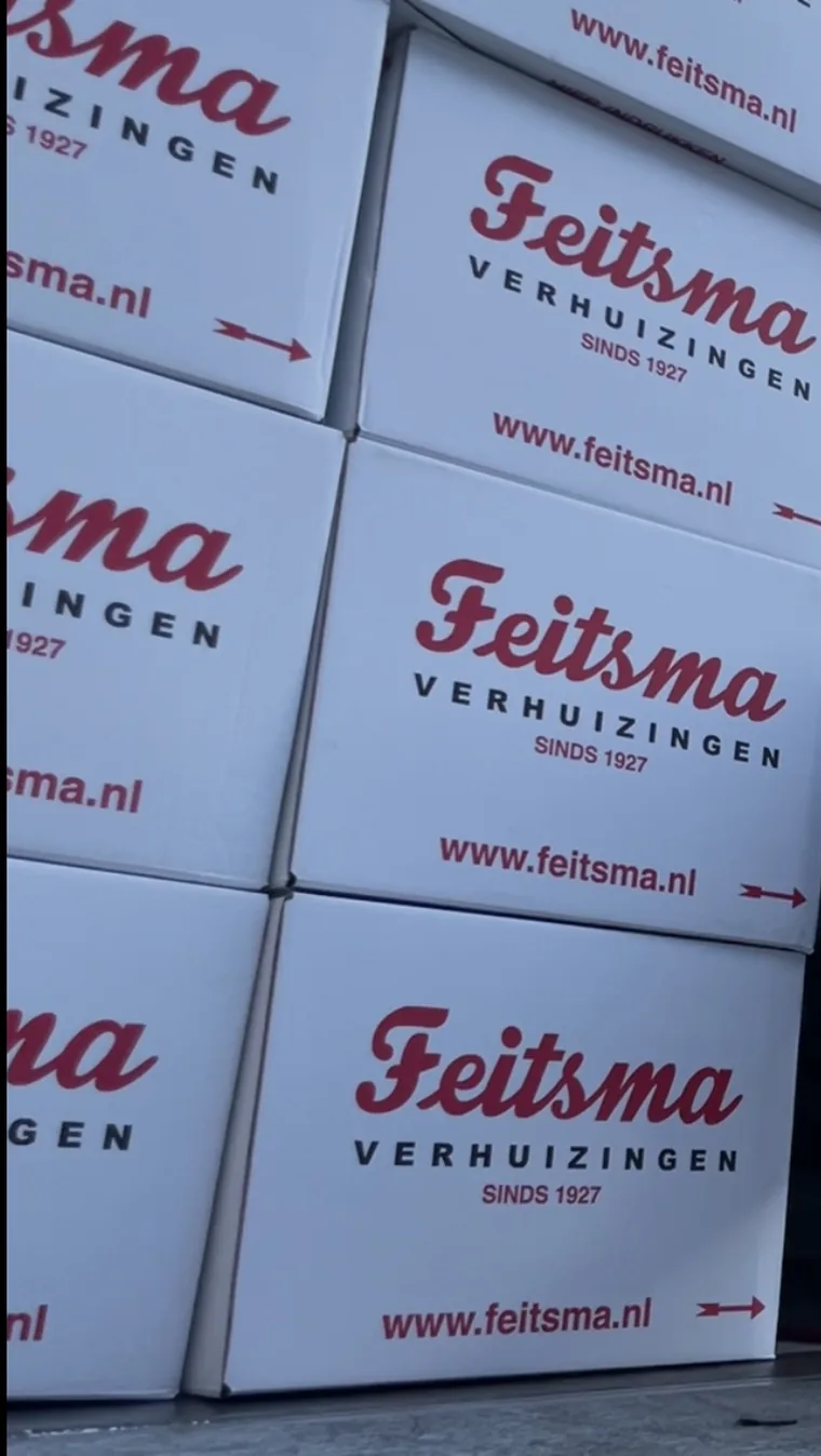 Gestapelde verhuisdozen met het logo van Feitsma Verhuizingen